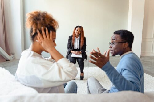 husband and wife having an argument during therapy session at therapist's office