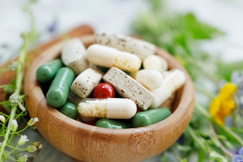 Vitamins and supplement capsules in a bowl. 